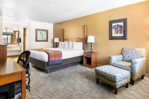 a hotel room with a bed and a chair at Best Western Grande River Inn & Suites in Grand Junction +25 photos