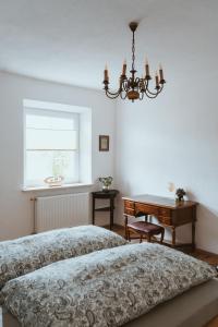 a bedroom with a bed and a desk and a chandelier at Villa Romantika in Ichenhausen