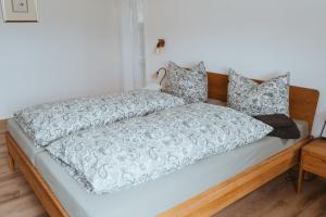 a white bed with a wooden headboard and pillows at Villa Romantika in Ichenhausen