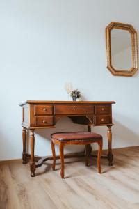 a wooden desk with a chair and a mirror at Villa Romantika in Ichenhausen