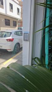a white car is parked outside of a building at Blue Mango Surf House Center in Puerto del Rosario