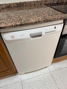 a dishwasher in a kitchen with a granite counter top at Costa Relax Beach Apartment with Pool & Tennis in Ifach