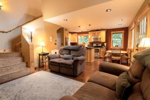 ein Wohnzimmer mit einem Sofa und Stühlen sowie eine Küche in der Unterkunft 2 Kings, Fire Pit, Gameroom, EV charger, Dogs OK! in Glacier