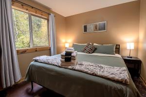 ein Schlafzimmer mit einem Bett mit zwei Lampen und einem Fenster in der Unterkunft 2 Kings, Fire Pit, Gameroom, EV charger, Dogs OK! in Glacier