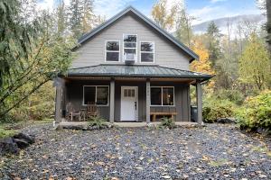 ein Haus mit einer Veranda mit 2 Stühlen in der Unterkunft 2 Kings, Fire Pit, Gameroom, EV charger, Dogs OK! in Glacier