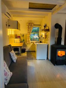 Una sala de estar con un sofá y una estufa. en Noclegi u Justyny, en Łagów