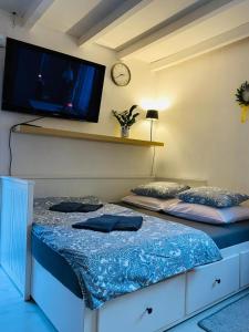 1 dormitorio con 2 camas y TV en la pared en Noclegi u Justyny, en Łagów 3 fotos más