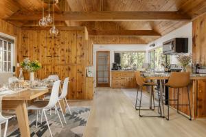 a kitchen with wooden walls and a table and chairs at Family Cabin With Hot Tub, Games, & Forest Views in Clio