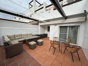 a living room with a couch and a table and chairs at El Rincón Glez in Alhama de Murcia