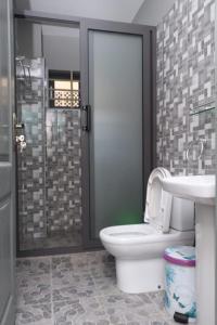 a bathroom with a toilet and a sink and a shower at Reliable Cosy Apartment 1 in Trofwi