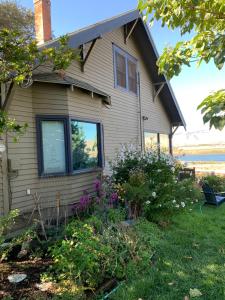 a house with a window and flowers in the yard at Riverhouse Hidden Gem in The Dalles +25 photos