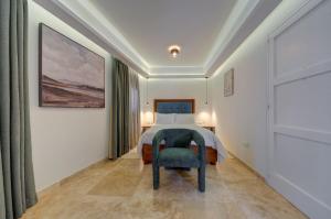 una camera da letto con un letto e una sedia di Ta Karmenu, an 800 year old modernized studio with terrace, by walk to Mdina a Rabat