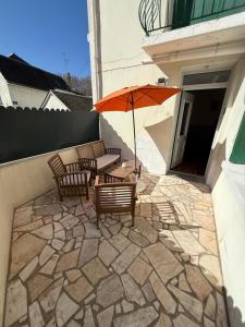 a patio with a table and chairs and an umbrella at Amboise Douceur de Vivre in Amboise