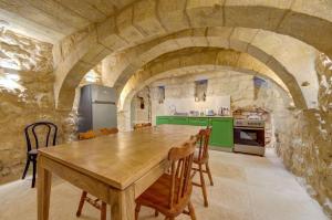 una cucina con tavolo in legno ed elettrodomestici verdi di Ta Karmenu, an 800 year old modernized studio with terrace, by walk to Mdina a Rabat
