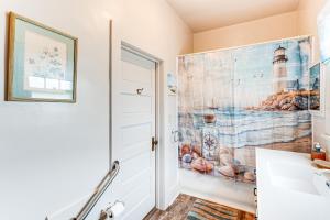 a bathroom with a painting of a lighthouse on the wall at Twin Lakes Cottage Walk to Elizabeth Lake! in Twin Lakes