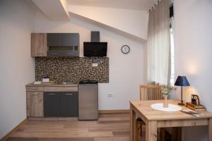 a kitchen with a stove and a table in a room at Velora apartments in Subotica