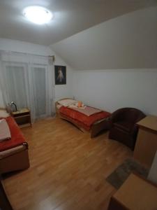 ein Zimmer mit einem Bett und einem Stuhl darin in der Unterkunft N i N in Međugorje