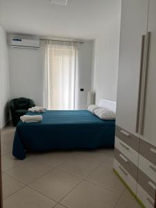 a bedroom with a blue bed and a window at Casa Mara in Macchie