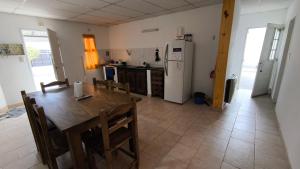 une cuisine et une salle à manger avec une table et un réfrigérateur dans l'établissement Casa con cochera y patio cerrado, Ruka del Rio, à Choele Choel
