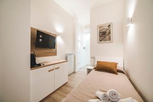 a small white room with a bed and a tv at Monteverde Vatican in Rome