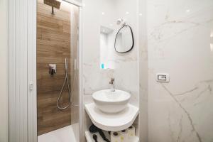 a white bathroom with a sink and a mirror at Monteverde Vatican in Rome +36 photos