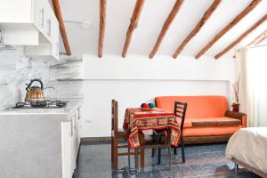 a kitchen with an orange chair and a table at Apart y Hostal "El Puma" in Cusco