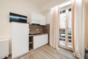 a kitchen with white cabinets and a large window at Monteverde Vatican in Rome