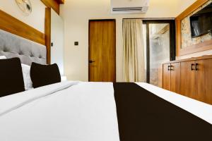 拉杰果德Hotel O The Infinity的卧室里有一张白色的大床和一扇窗户 更多21张照片