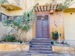 a door on the side of a building with some plants at Dar Alsalam Suites in Siwa