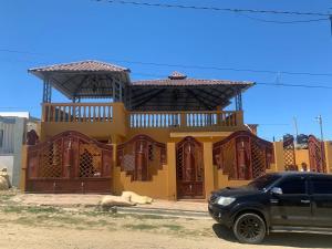 a black suv parked in front of a yellow building at Casa modesta para disfrutar in Colorado