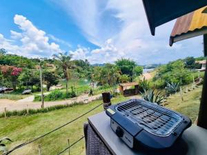 a grill sitting on a table with a view of a park at Chalé do Beijo in Nazaré Paulista