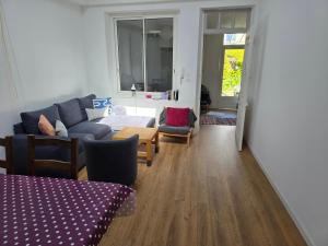 Una sala de estar con un sofá azul y sillas. en Maison proche du port de La Ciotat, en La Ciotat