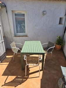 una mesa verde y sillas en un patio en Maison proche du port de La Ciotat, en La Ciotat 2 fotos más