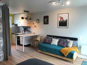 a living room with a couch and a kitchen at Taminimaison in Laval