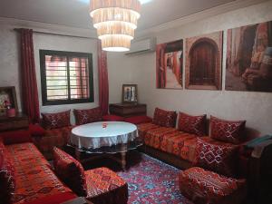 a living room with red couches and a table at moroccan traditional equipped apartment in Marrakech