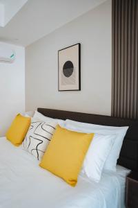 a white bed with two yellow pillows on it at Solace III in Kingston +32 photos