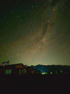 Una notte stellata con una casa e la via lattea di Cabañas Tierra Adentro a Uspallata