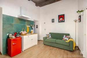 a living room with a green couch and a kitchen at Bernadette Boutique in Naples