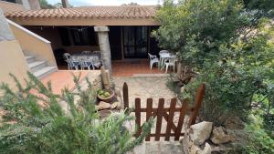 a fence in front of a house with a table and chairs at Casa Azul villa e piscina relax Costa Paradiso Sardegna in Costa Paradiso