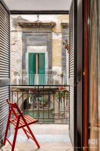 a red chair in front of a window with a building at Bernadette Boutique in Naples