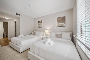 two white beds in a room with a window at Promo Casa Miel Heart of Westwood Luxury Condo in Los Angeles +19 photos