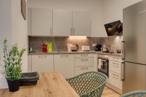 a kitchen with white cabinets and a wooden table at TheFamilyNest in Amberg