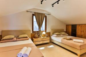 a bedroom with two beds and a window at Casa Brilla in Tivat