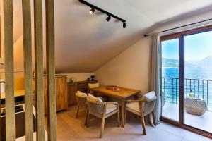 a dining room with a table and a balcony at Casa Brilla in Tivat