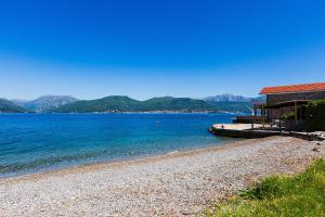 a house on the shore of a lake with mountains at Casa Brilla in Tivat
