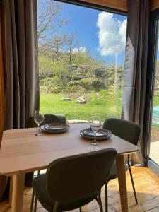 a wooden table with two wine glasses and a window at Madera House in Herceg-Novi