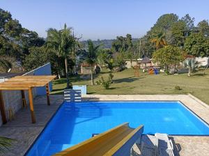 a pool with a picnic table and a playground at Chacara Mairinque - Paraiso in Mairinque