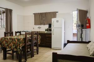 a kitchen with a table and a white refrigerator at La Tranquilidad in Merlo