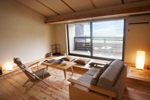 熊野市にある世界遺産リゾート　熊野倶楽部のリビングルーム(ソファ、テーブル付)、大きな窓が備わります。