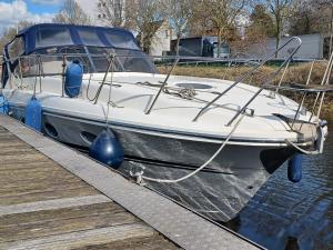 a white boat is docked next to a dock at Motoryacht ELENA in Eeklo